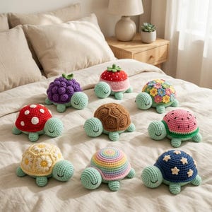 May include: A collection of nine crocheted turtle plushies with light green heads and limbs. Each turtle features a unique shell design, including patterns of grapes, strawberries, flowers, mushrooms, brown textures, watermelon, daisies, rainbows, and stars.