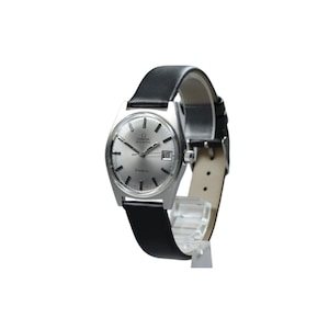 May include: An Omega Genève automatic wristwatch with a silver dial, silver-tone hour markers, and a date window at the three o'clock position. The watch features a stainless steel case and a smooth black leather strap with a silver-tone buckle.