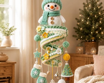 May include: A hanging crochet mobile featuring a white snowman with a mint green hat and scarf at the top. Below, a spiral structure is decorated with yellow and white flowers, green pom-poms, two mint mittens, a small Christmas tree, and a white snowflake.