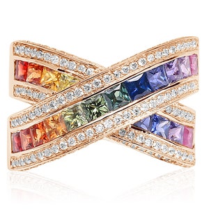 Puede incluir: Un anillo de oro con un arcoíris de zafiros y diamantes. El anillo está engastado en un patrón de cruz.