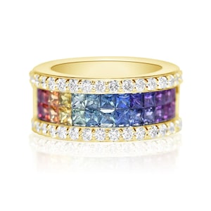 May include: A gold band ring with a row of square-cut sapphires in a rainbow gradient, surrounded by a border of round diamonds.
