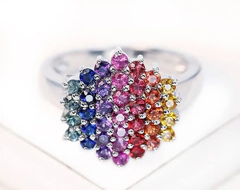 May include: A silver ring with a rainbow of colorful gemstones set in a flower shape.
