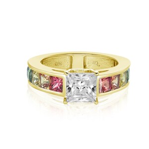 May include: A gold ring with a large square-cut center stone and a band of smaller square-cut stones in shades of green, pink, and yellow.