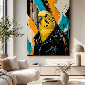 Op de afbeelding: Een ingelijste muurkunstprint met een gele grasparkiet die een zwart leren jack met zilveren studs draagt. De achtergrond bestaat uit abstracte diagonale strepen in feloranje, turquoise en wit met verfdruppeleffecten.