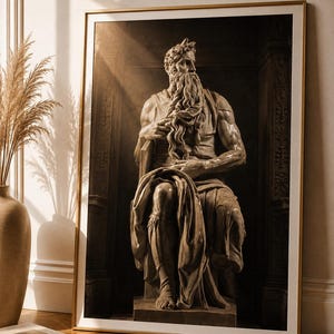 Könnte beinhalten: Ein gerahmter Kunstdruck mit einer sepiafarbenen Darstellung einer sitzenden, bärtigen Figur mit Hörnern, die an Michelangelos Moses erinnert. Das Kunstwerk ist in einem dünnen goldenen Rahmen mit weißem Passepartout gefasst und zeigt skulpturale Details.