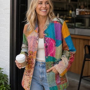 Könnte beinhalten: Eine langärmelige Jacke mit einem lebendigen Patchwork-Design aus verschiedenen bunten Stoffmustern, einem Stehkragen und einer Knopfleiste vorne. Die Jacke wird über einem weißen Tanktop und einer hellblauen Jeans getragen, mit sichtbaren Nähten.