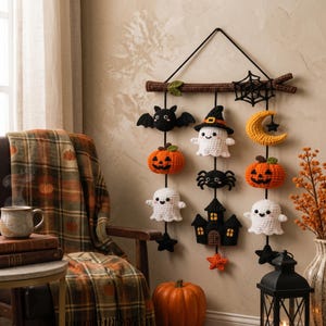 Puede incluir: Un adorno de pared con figuras de Halloween tejidas a ganchillo suspendidas de una rama marrón. Las figuras incluyen un murciélago negro, un fantasma blanco con sombrero de bruja, una luna creciente amarilla, dos calabazas naranjas, una araña, una casa encantada y estrellas.