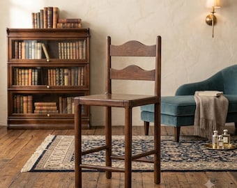 May include: A dark brown wooden bar stool featuring a ladder-back design with two horizontal slats, a square seat, and four straight legs connected by footrests on all sides. The stool is constructed from solid wood with a smooth finish.
