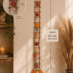 Könnte beinhalten: Eine vertikale Wanddekoration in Form einer Strickleiter, verziert mit verschiedenen Muscheln in Orange-, Rot- und Weißtönen. Die Gesamthöhe beträgt 67 cm bei einer Breite von 8 cm. Jeder einzelne Muschelabschnitt ist 10 cm hoch und 6 cm breit.