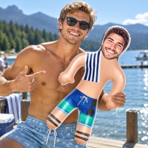 Peut inclure: Une poupée gonflable personnalisée avec la photographie imprimée du visage d'un homme souriant. La poupée porte un débardeur à rayures bleu marine et blanc ainsi qu'un short de bain bleu avec des bandes horizontales vertes et noires.