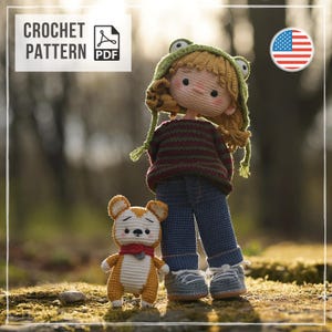May include: A crochet pattern PDF featuring a doll with blonde hair wearing a green frog hat, a striped sweater, blue pants, and grey shoes, standing next to a small orange and white animal figure with a red scarf and a grey collar.