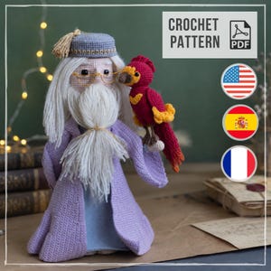May include: A crochet pattern PDF for a doll of an elderly wizard with a long white yarn beard, wearing a lavender robe and a matching hat with a gold tassel. The wizard wears gold wire glasses and holds a small red and yellow phoenix bird.