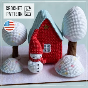 May include: A crochet pattern PDF featuring a red house with a light blue roof, a snowman wearing a red hat and scarf, two white trees with brown trunks, and two small white mounds with colorful speckles, all crafted in a winter theme.