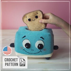 May include: A light blue crocheted toaster with a smiling face, large white eyes, and dark grey accents. A tan crocheted slice of bread with a smiling face and pink cheeks is being placed into the top slot of the toaster. The item is a crochet pattern.