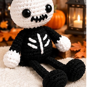 Peut inclure: Une poupée squelette au crochet avec une grande tête ronde blanche, des yeux en boutons noirs et une bouche noire cousue. Le corps est noir avec des coutures blanches en forme de côtes sur la poitrine, des mains blanches et des jambes noires.