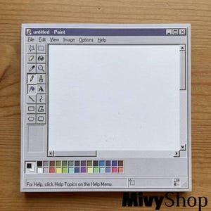 May include: A square notepad featuring a graphic print of a classic computer paint software interface. The design includes a toolbar with icons, a large white central canvas area, a color palette at the bottom, and the text untitled - Paint.