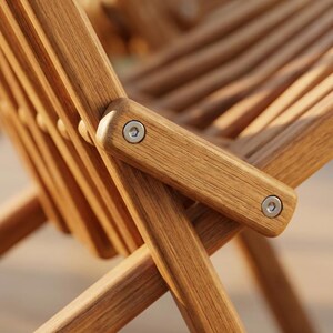 May include: A folding chair constructed from light brown wood with a slatted seat and backrest. The frame features visible metal bolts at the joints, connecting the legs and armrests in a cross-brace design with a natural wood grain finish.