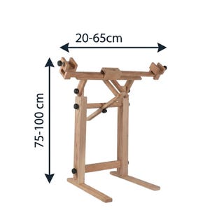 May include: A light brown wooden floor stand with adjustable clamps and support arms. The stand features black adjustment knobs and is labeled with dimensions of 20-65cm for width and 75-100cm for height, indicating its adjustable range.