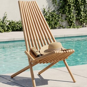 May include: A light-colored wooden lounge chair with a slatted back and seat design. A beige straw hat with a brown ribbon and a small tan tube of sunscreen are resting on the seat of the chair, which features a folding frame construction.