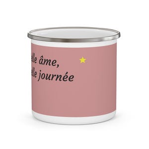 Peut inclure: Un mug en émail rose poudré avec un bord argenté. Le mug présente le texte noir "belle âme, belle journée" et une petite étoile jaune imprimée sur le côté. L'intérieur du mug est blanc et la surface extérieure est d'une couleur rose sourde.