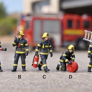 May include: Five miniature firefighter figurines labelled A through E, wearing dark navy uniforms with yellow reflective stripes and yellow helmets. They are depicted in various poses with equipment including a hose, radio, extinguisher, and ladder.