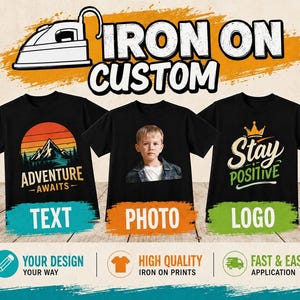 May include: Three black t-shirts featuring custom iron-on designs. The left shirt shows a mountain graphic with the text ADVENTURE AWAITS. The centre shirt displays a child's portrait. The right shirt features a crown icon and the text Stay POSITIVE.