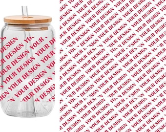 May include: A set of 3PCS UV DTF cup wraps featuring the repeating red text YOUR DESIGN. The image displays a clear glass tumbler with a bamboo lid and a straw, alongside a flat sheet showing the repeating red text pattern for application.