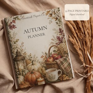 May include: An Autumn Planner with a 33-page printable digital download label. The cover features illustrations of pumpkins, a lantern, a basket of apples, and a mug, framed by autumn leaves and acorns with the text Heartside Paper Co.