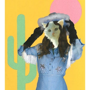 Op de afbeelding: Een witte kat met een blauwe en witte cowboyhoed, die een blauwe denimjurk met zilveren sterren draagt, tegen een gele achtergrond met een roze cirkel en een groene cactus.