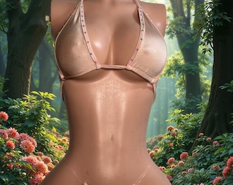 Può includere: Un set bikini color champagne scintillante composto da un top a triangolo e uno slip a perizoma. Entrambi i pezzi sono decorati con piccoli borchie color argento regolarmente distanziate lungo i bordi. Il bikini è esposto su un busto di manichino.