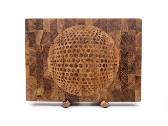 Orbital geometric end-grain oak with hardwood inlay — the kind of board you hang on the wall AND use to prep dinner.