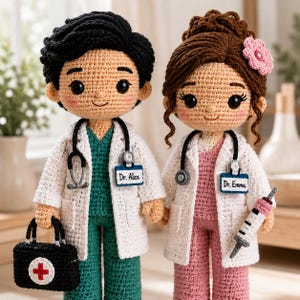 Puede incluir: Dos muñecos de ganchillo vestidos como profesionales médicos. Uno tiene pelo negro, uniforme verde, bata blanca, estetoscopio y maletín médico negro con una cruz roja. El otro tiene pelo castaño con una flor rosa, uniforme rosa, bata blanca, estetoscopio y una jeringuilla. Las etiquetas de nombre dicen Dr. Alex y Dr. Emma.