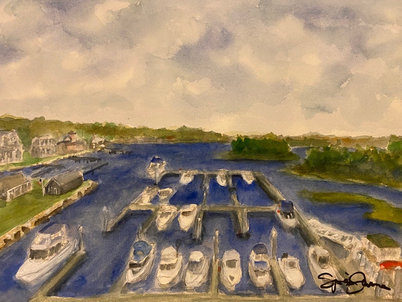 Op de afbeelding: Een aquarel schilderij van een jachthaven met boten die in rijen aangemeerd liggen. De boten zijn wit en het water is diepblauw. De lucht is bewolkt en grijs. Er zijn bomen en gebouwen op de achtergrond.