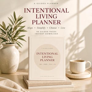 Może przedstawiać: Kremowy planer z napisem Intentional Living Planner ciemnoczerwoną czcionką. Okładka zawiera centralne koło, frazę Align, Simplify, Choose, Live oraz 38 stron z poradami. Planer leży na stosie książek obok białego kubka.