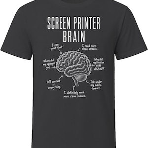 May include: A charcoal gray short-sleeve t-shirt featuring a white graphic of a human brain with arrows pointing to text that reads: SCREEN PRINTER BRAIN, I can print that!, I need more clean screens., Why did registration drift AGAIN!?, Ink under my nails, forever., I definitely need more clean screens., Off contact is everything., Where did my squeegee go?.