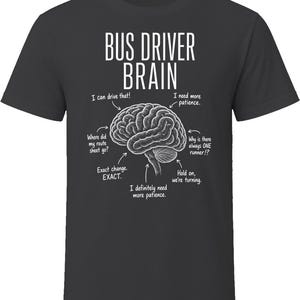 May include: A black short-sleeve t-shirt featuring a white graphic of a human brain. The text reads BUS DRIVER BRAIN with arrows pointing to various parts of the brain labeled with phrases like I can drive that, I need more patience, and Exact change.