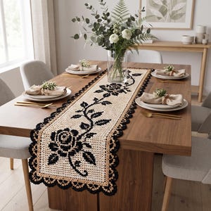 Pode incluir: Um caminho de mesa retangular de crochê com um padrão de grade bege e um motivo de trepadeira de rosas pretas no centro. O caminho tem uma borda decorativa de renda preta recortada e está sobre uma mesa de jantar de madeira.