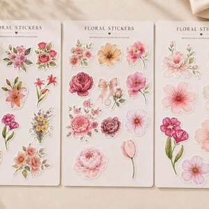 May include: Three rectangular sheets of floral stickers, each labelled FLORAL STICKERS at the top. The sheets feature various watercolour-style illustrations of pink, red, orange, and yellow flowers, bouquets, and a small bow, all on a cream background.