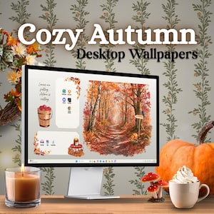 Op de afbeelding: Een computermonitor met een digitaal herfstbos-achtergrond en de tekst Cozy Autumn Desktop Wallpapers. Het scherm toont iconen, een emmer appels en een kaars. Een echte kaars, een pompoen en een mok staan voor het scherm.