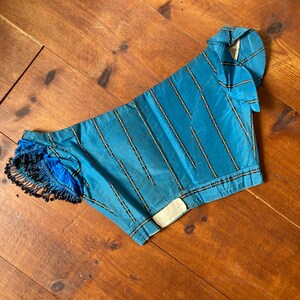 very old victorian tiny bodice, corset era, in bright blue silk with a horizontal stripe. it has bones and is very small. it has tiny sleeves and the original beaded fringes are still there on one of the slvees. museum piece.
