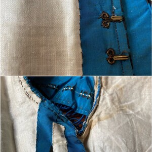 May include: Close-up of a blue and white fabric with a black and white geometric pattern. The fabric is sewn together with a white thread. The fabric is folded over and the edges are visible.