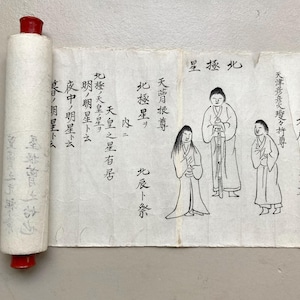 May include: An antique Japanese scroll featuring illustrations and calligraphy. The scroll is rolled with a red cap at one end. The unrolled section shows figures and text in black ink on aged paper.