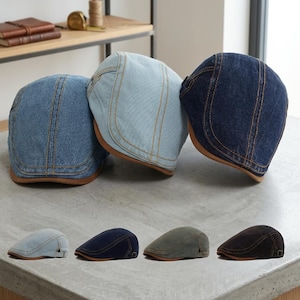May include: Three flat caps in light blue, medium blue, and dark blue denim with contrast stitching and brown brims. Below, four additional flat caps are displayed in light blue, dark blue, olive green, and dark brown, each featuring a side buckle.
