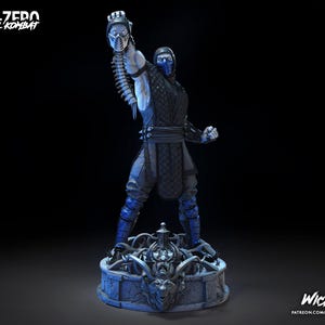 May include: A Sub-Zero Mortal Kombat figurine standing on a detailed circular base. The character wears a black and blue ninja outfit with a mask, holding a severed head and spine aloft in one hand. Text reads SUB-ZERO MORTAL KOMBAT and WICKED.