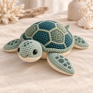 Può includere: Un peluche a forma di tartaruga marina realizzato all'uncinetto con un guscio a motivi esagonali color verde ottanio scuro e verde salvia. La testa e le pinne sono verde salvia chiaro con macchie verde scuro, il ventre è color crema con occhi neri.
