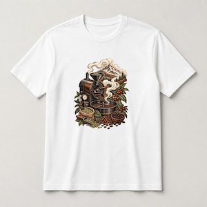 May include: A white short-sleeve t-shirt featuring a central graphic illustration of a vintage coffee roasting machine, steam rising toward a mountain peak, surrounded by green coffee leaves, red coffee cherries, and piles of roasted beans.