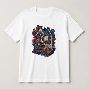 May include: A white short-sleeve t-shirt featuring a central graphic of a modular synthesizer with numerous patch cables. The design includes swirling abstract shapes in shades of blue, orange, and red surrounding the electronic instrument.