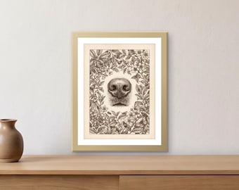 May include: A framed art print featuring a detailed brown ink illustration of a dog nose centered within a dense botanical wreath of flowers, leaves, and small insects. The artwork is encased in a simple gold frame with a white mat border.