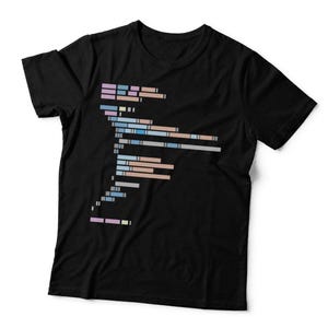 May include: A black short-sleeved t-shirt featuring a central graphic design composed of horizontal rectangular bars in shades of light blue, peach, and lavender, arranged in a vertical, abstract, and fragmented column pattern.