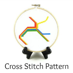 May include: A cross stitch pattern of a colorful subway map design, framed in a wooden hoop and displayed on a black stand.